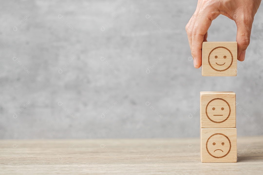 Mão de homem segurando o bloco de rosto de emoção. Cliente escolhe Emoticon.
