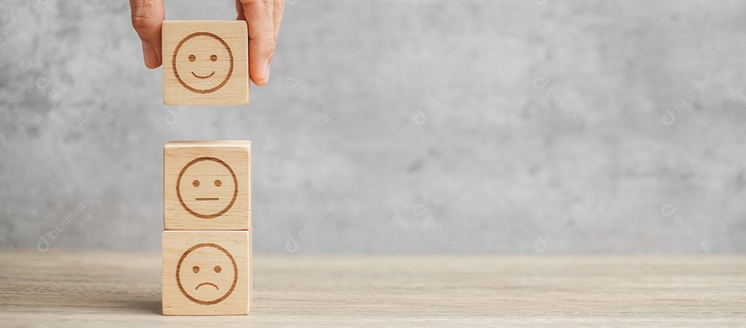 Mão de homem segurando o bloco de rosto de emoção. Cliente escolhe Emoticon.