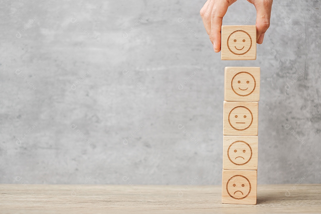 Mão de homem segurando o bloco de rosto de emoção. Cliente escolhe Emoticon.