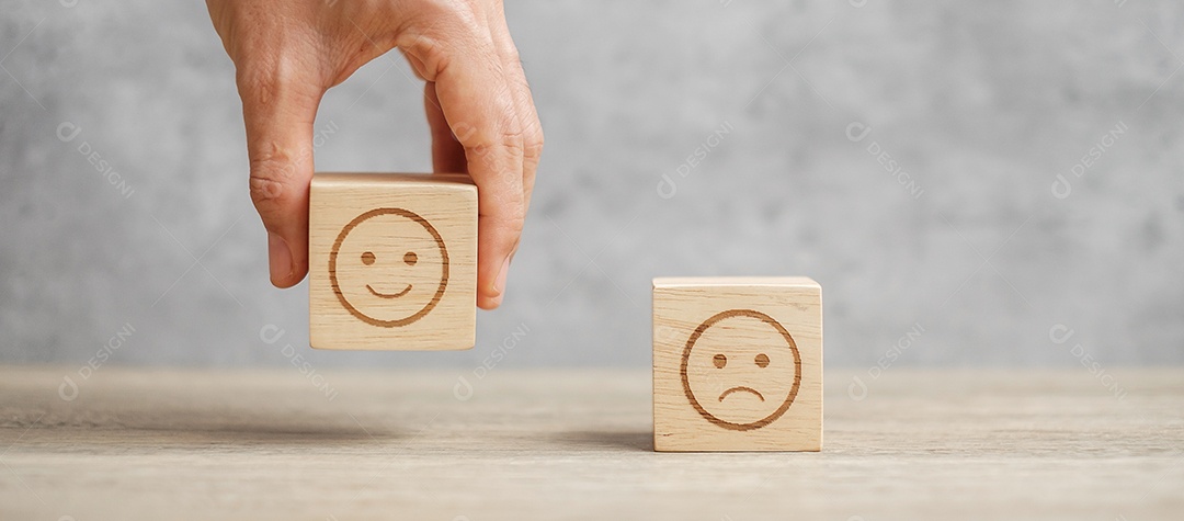 Mão de homem segurando o bloco de rosto de emoção. Cliente escolhe Emoticon.