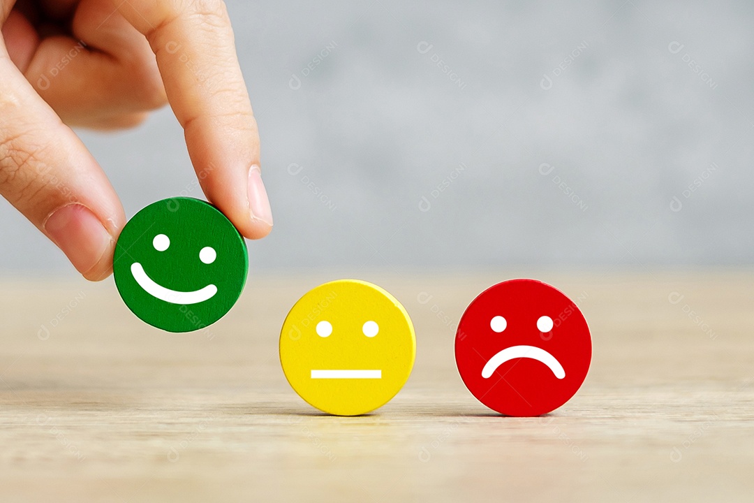 Mão segurando o bloco de rosto de emoção. O cliente escolhe o Emoticon para nós.