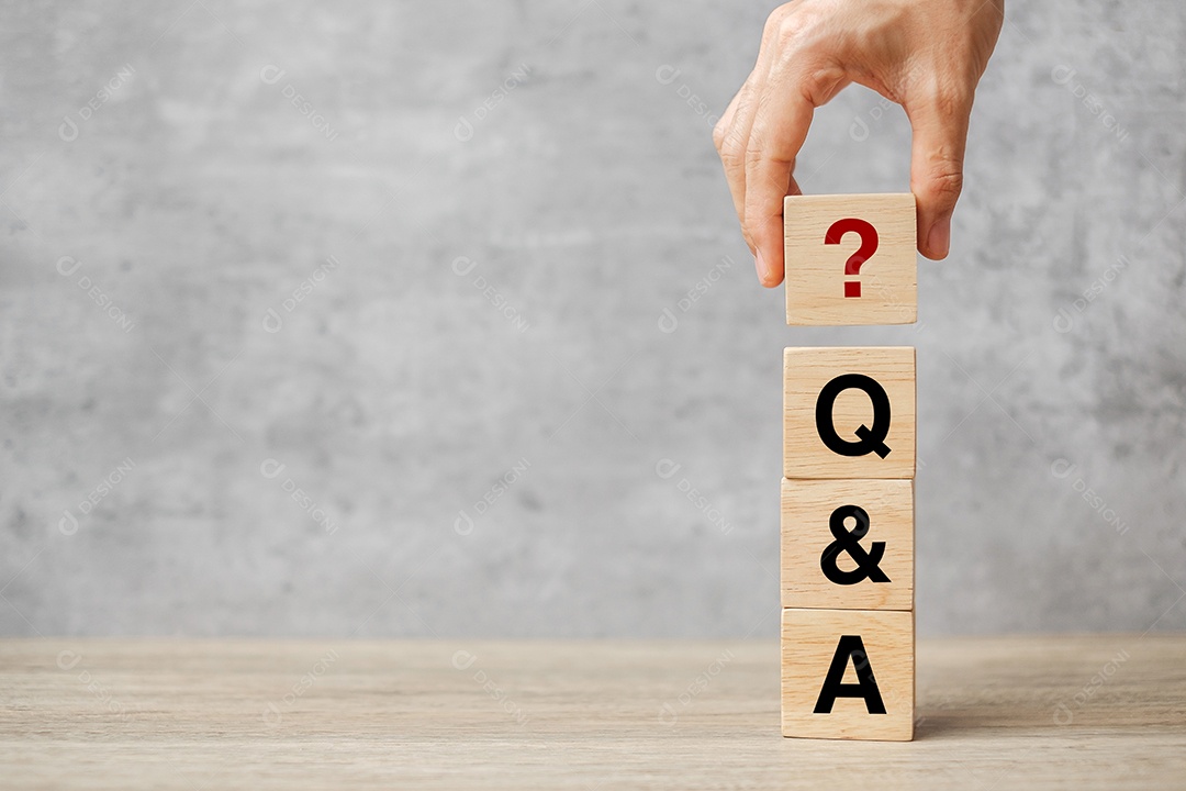 Mão segurando a palavra Q e A com bloco de madeira.