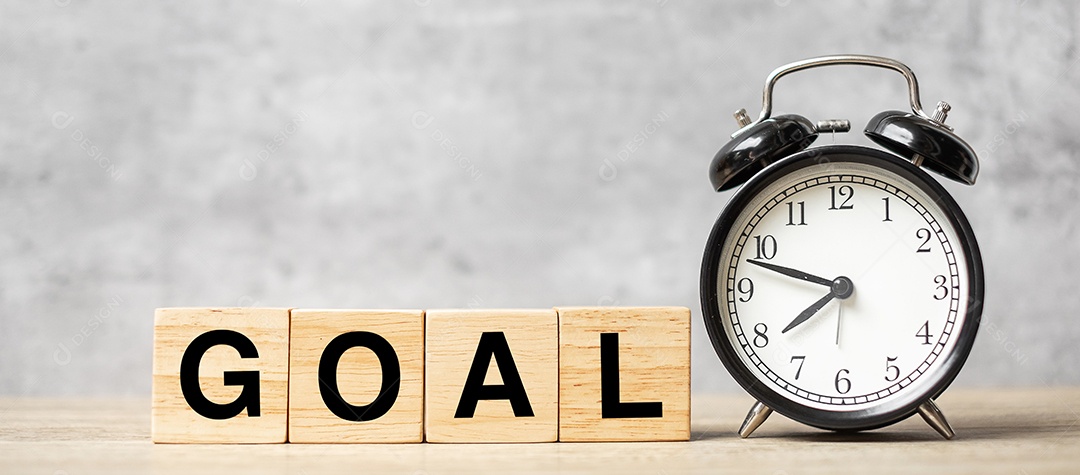 Despertador vintage com bloco de OBJETIVO na mesa.