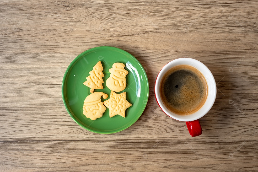 Feliz Natal com biscoitos caseiros e xícara de café na aba de madeira.