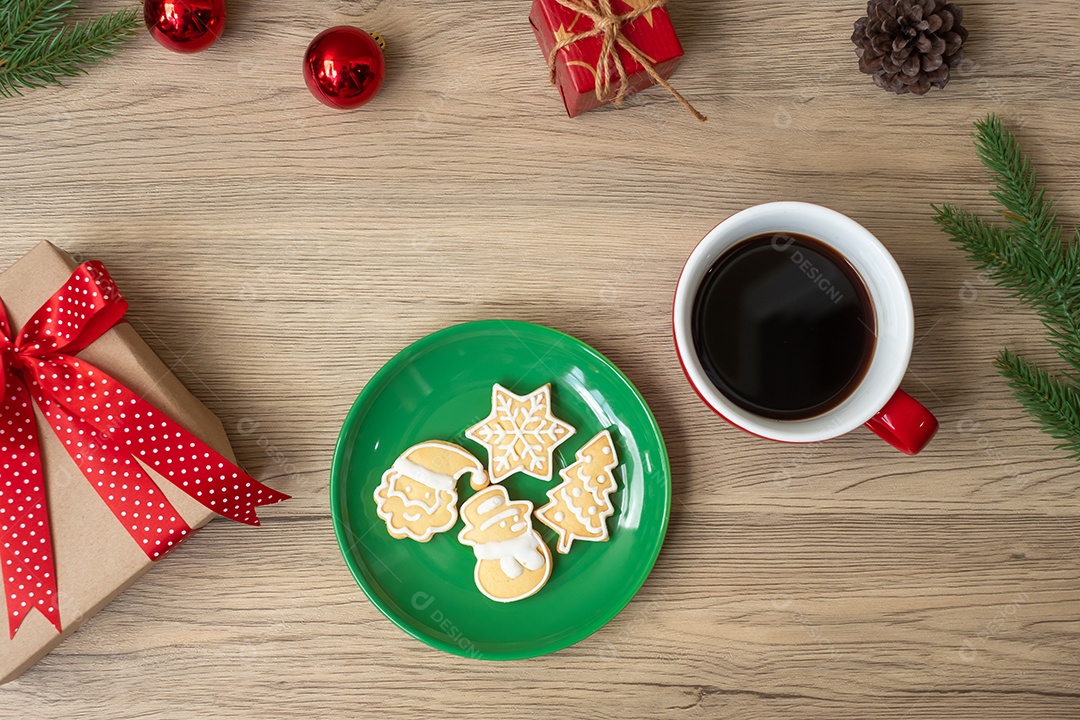 Feliz Natal com biscoitos caseiros e xícara de café na aba de madeira.