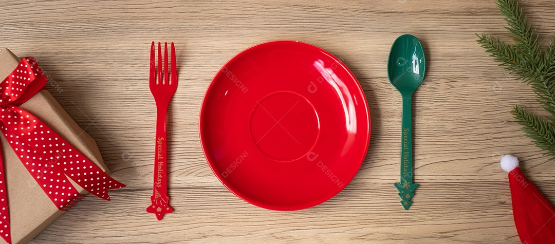 Feliz Natal com prato, garfo e colher na mesa de madeira.