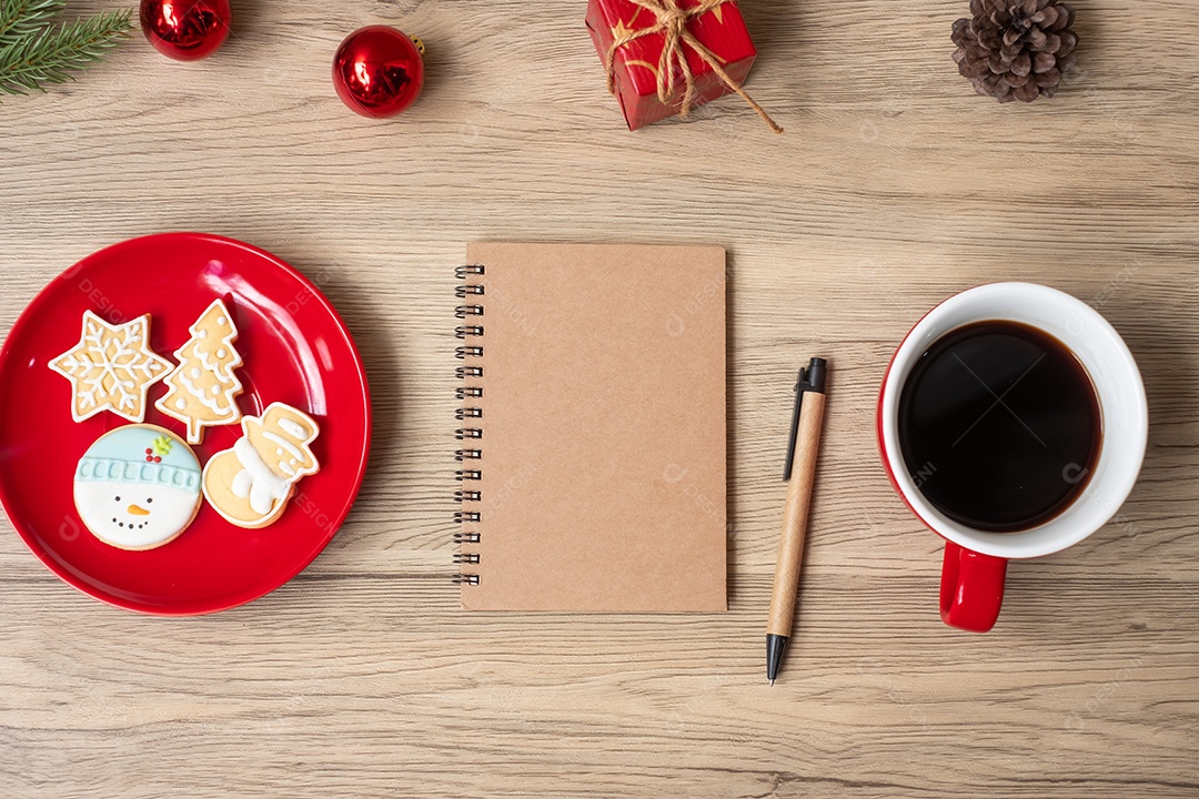 Caderno em branco, xícara de café preto, biscoitos de Natal e caneta.