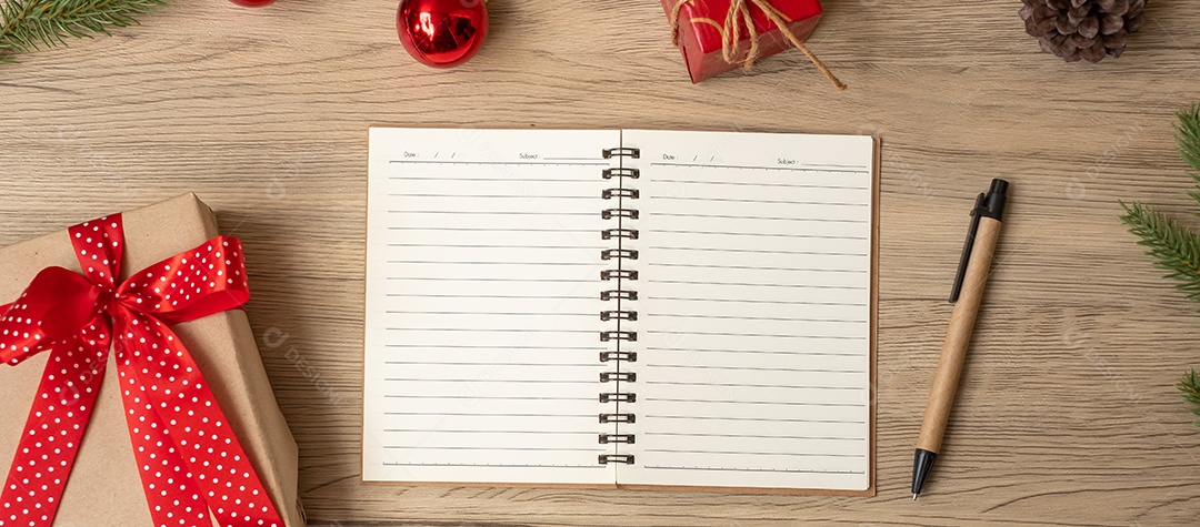 Caderno em branco, presente de Natal e caneta na mesa de madeira, vista superior.