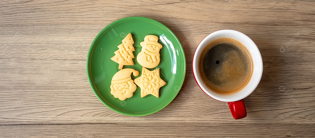 Feliz Natal com biscoitos caseiros e xícara de café na aba de madeira.