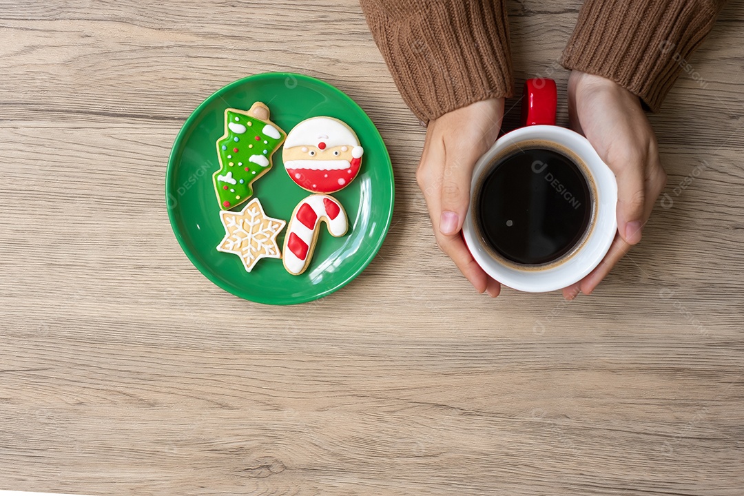 Feliz Natal com mão de mulher segurando xícara de café e caseiro.