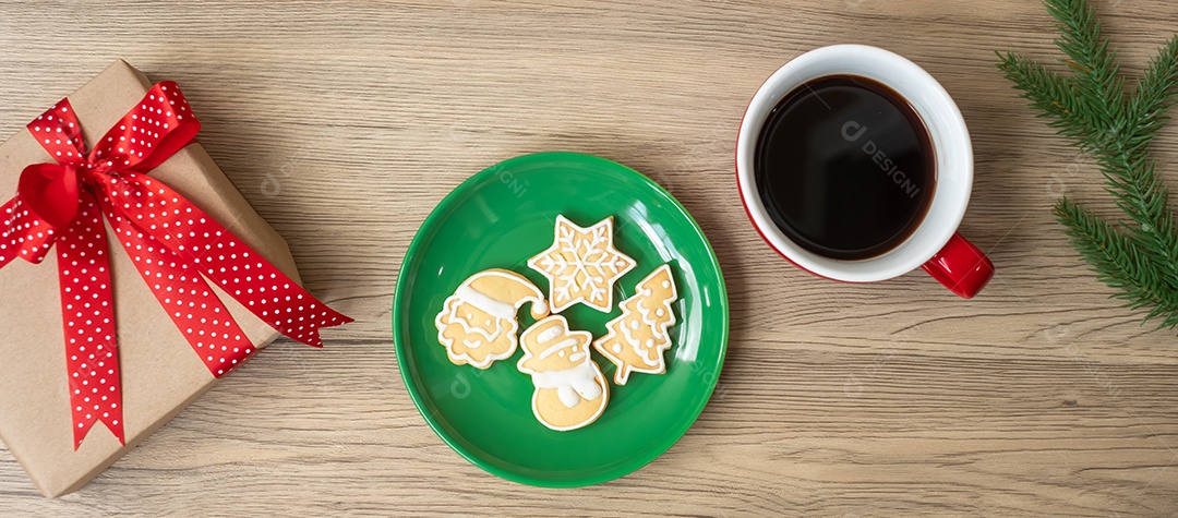 Feliz Natal com biscoitos caseiros e xícara de café na aba de madeira.