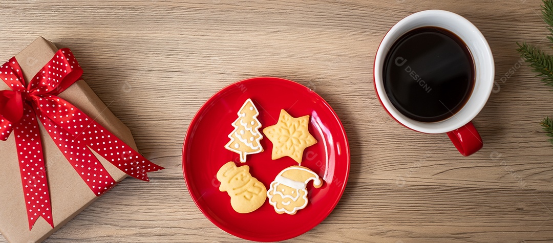 Feliz Natal com biscoitos caseiros e xícara de café na aba de madeira.