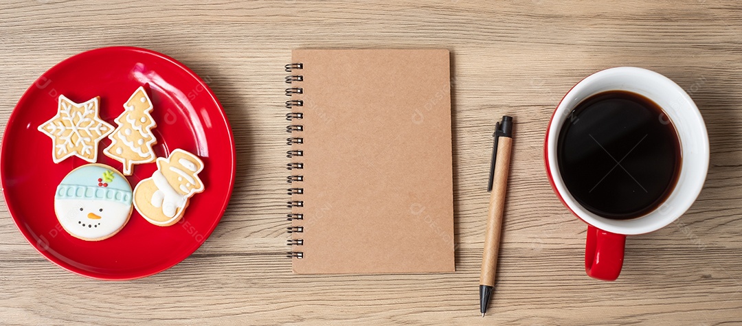 Caderno em branco, xícara de café preto, biscoitos de Natal e caneta.