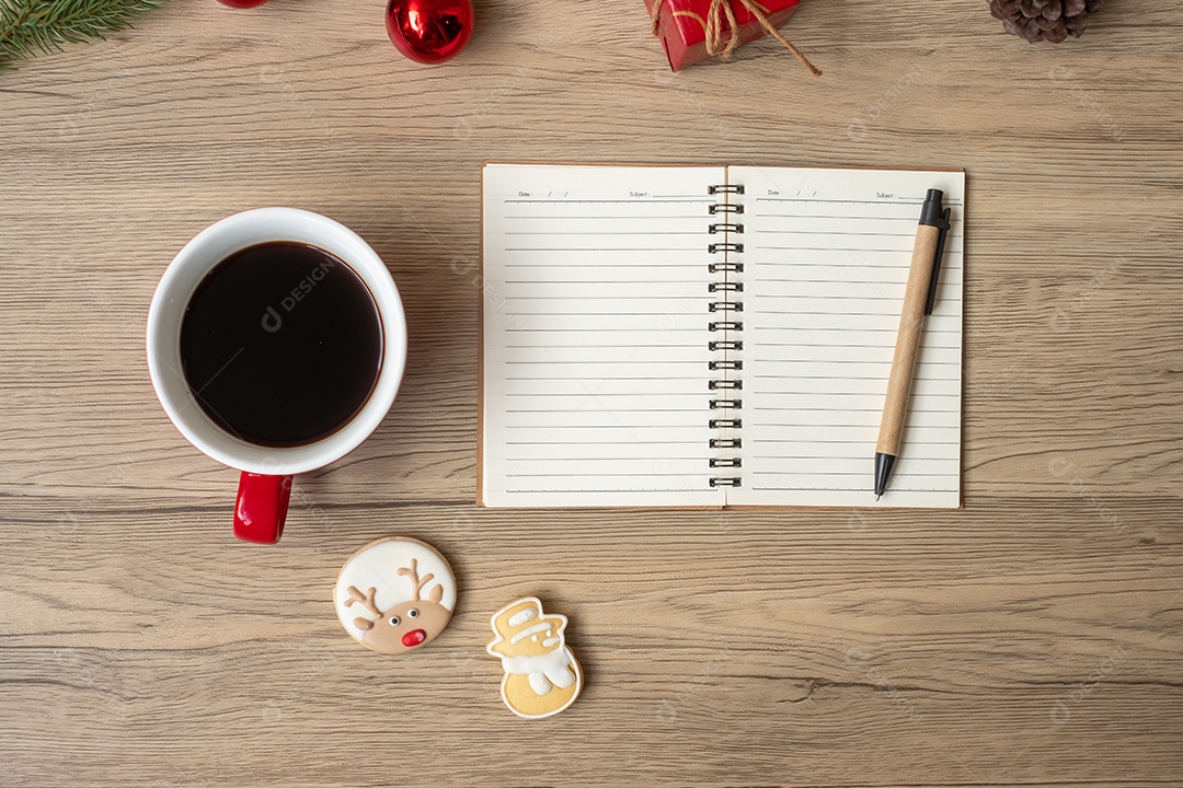 Caderno em branco, xícara de café preto, biscoitos de Natal e caneta.