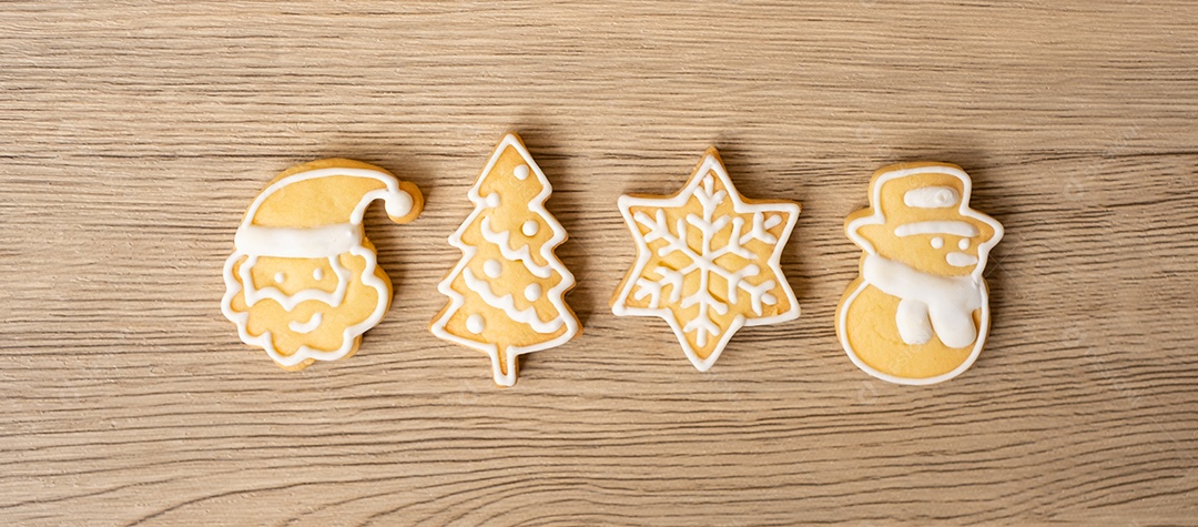 Feliz Natal com biscoitos caseiros no fundo da mesa de madeira.