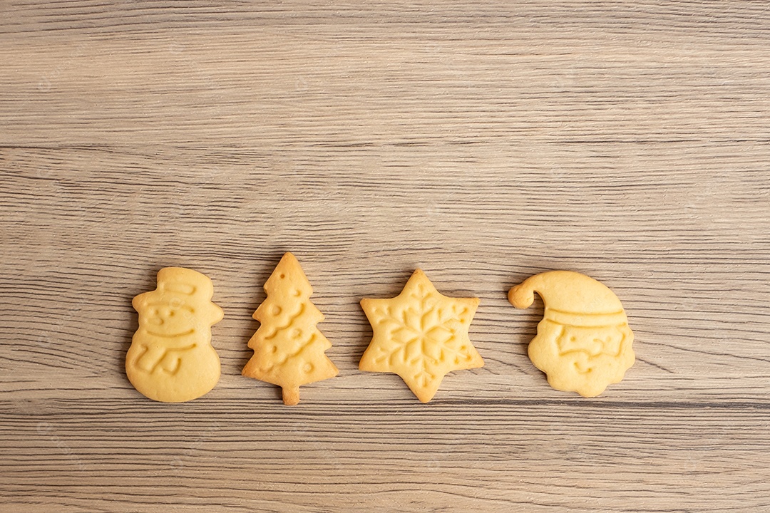 Feliz Natal com biscoitos caseiros no fundo da mesa de madeira.