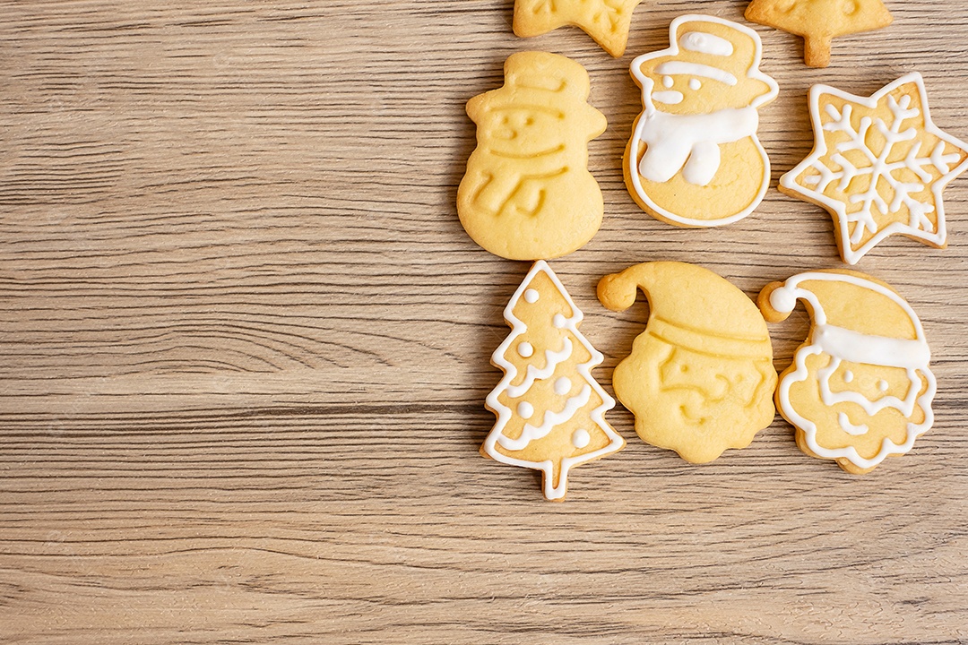 Feliz Natal com biscoitos caseiros no fundo da mesa de madeira.