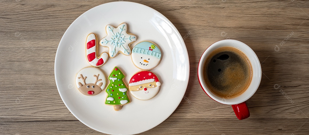 Feliz Natal com biscoitos caseiros e xícara de café na aba de madeira.