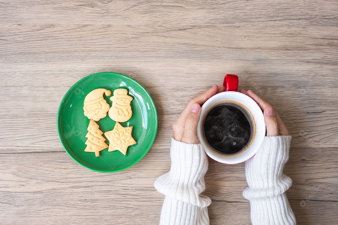 Feliz Natal com mão de mulher segurando xícara de café e caseiro.