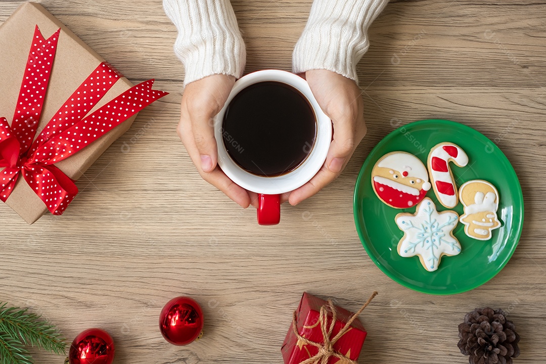 Feliz Natal com mão de mulher segurando xícara de café e caseiro.