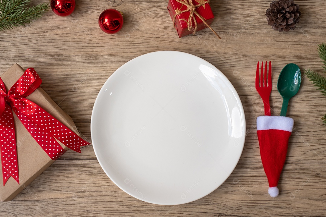 Feliz Natal com prato, garfo e colher na mesa de madeira.