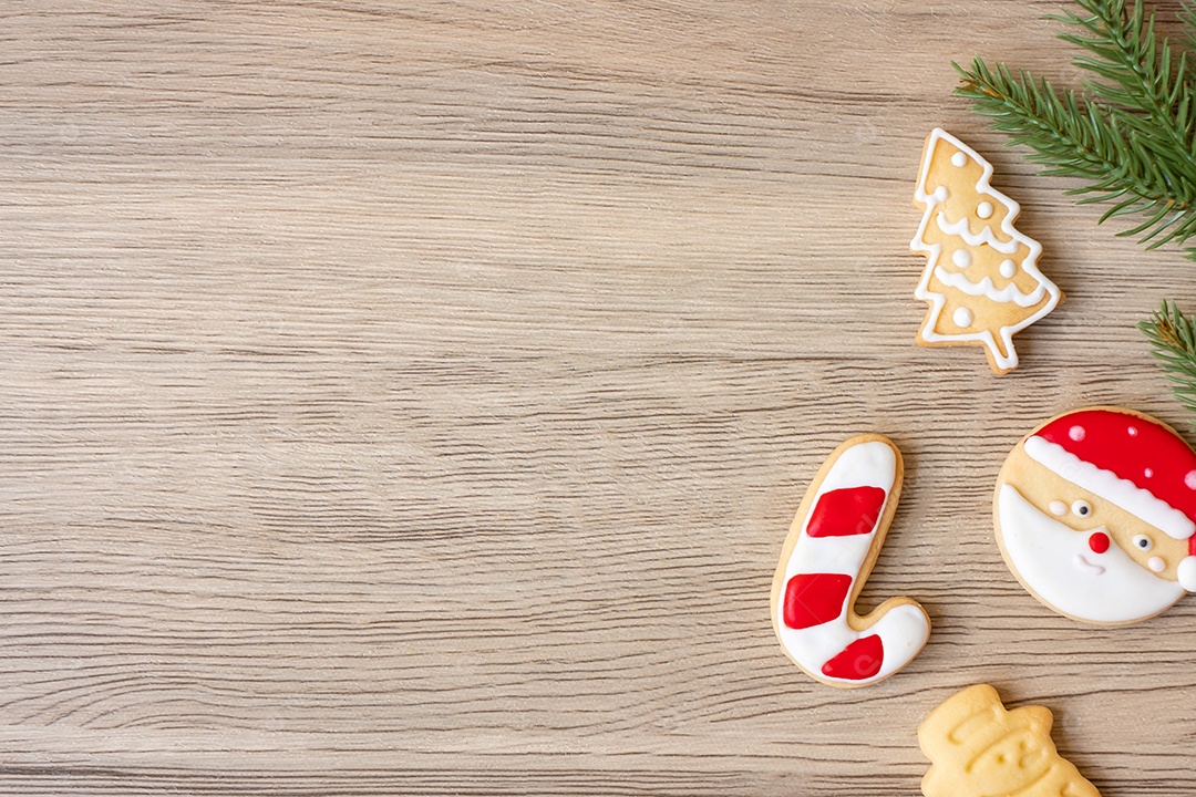 Feliz Natal com biscoitos caseiros no fundo da mesa de madeira.