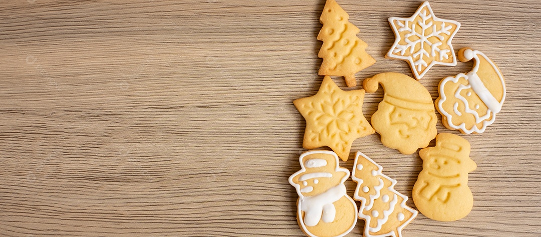 Feliz Natal com biscoitos caseiros no fundo da mesa de madeira.