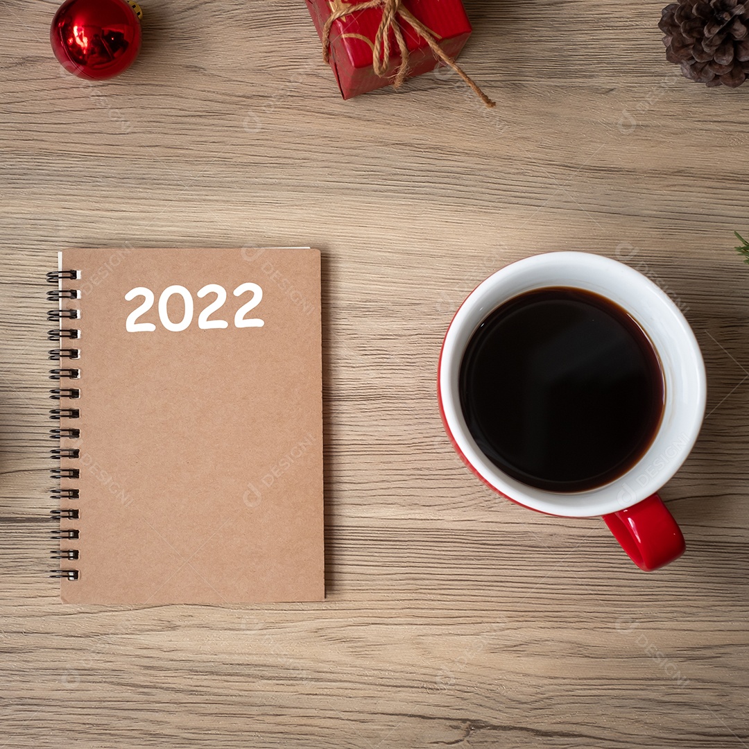 Caderno 2022, xícara de café preto e presente de Natal na mesa de madeira.