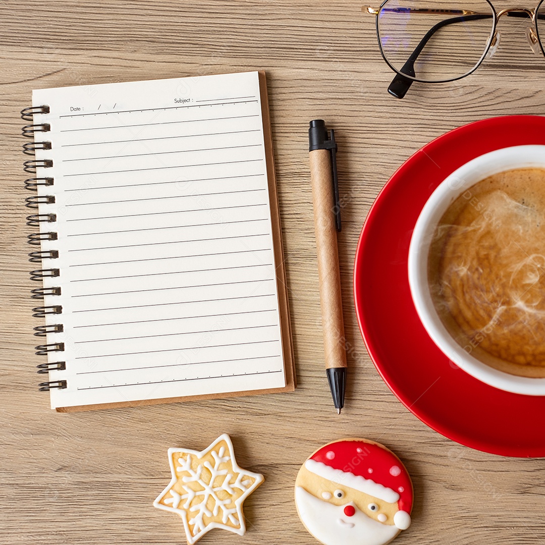 Caderno em branco, xícara de café preto, biscoitos de Natal e caneta.