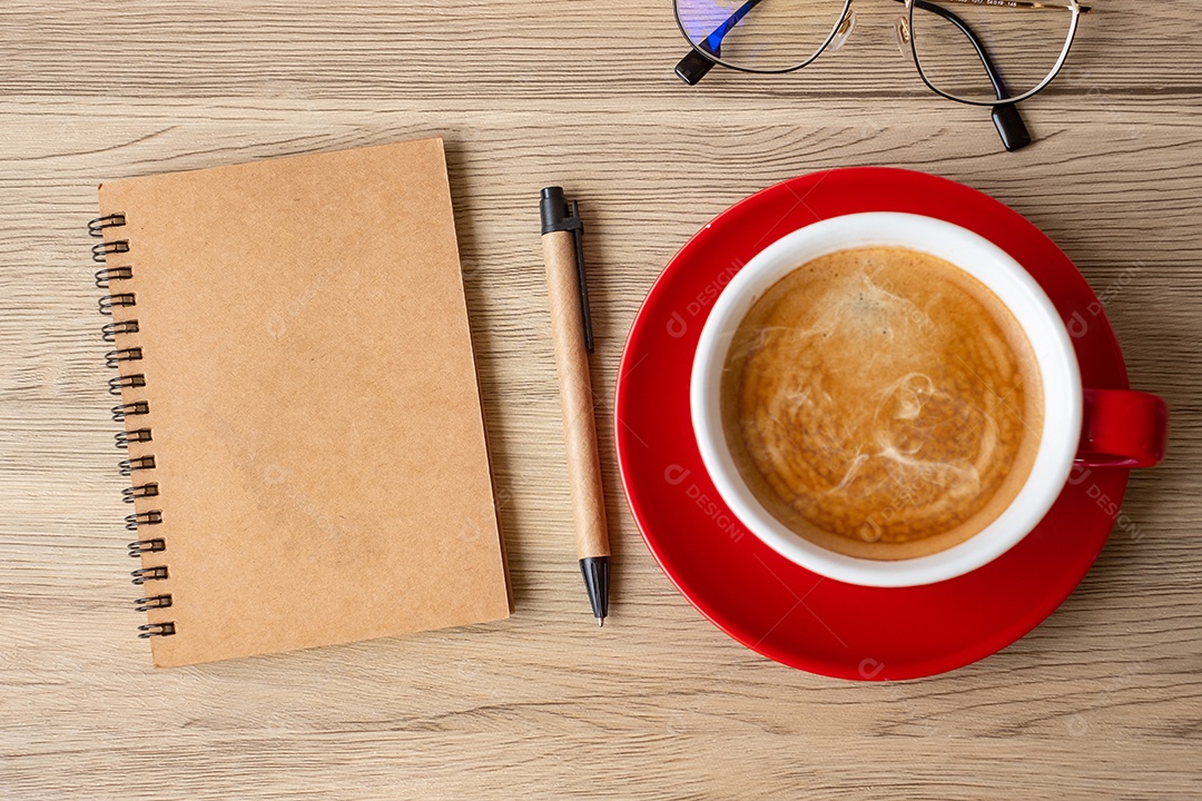Caderno em branco e xícara de café na mesa de madeira. Motivação, determinação.