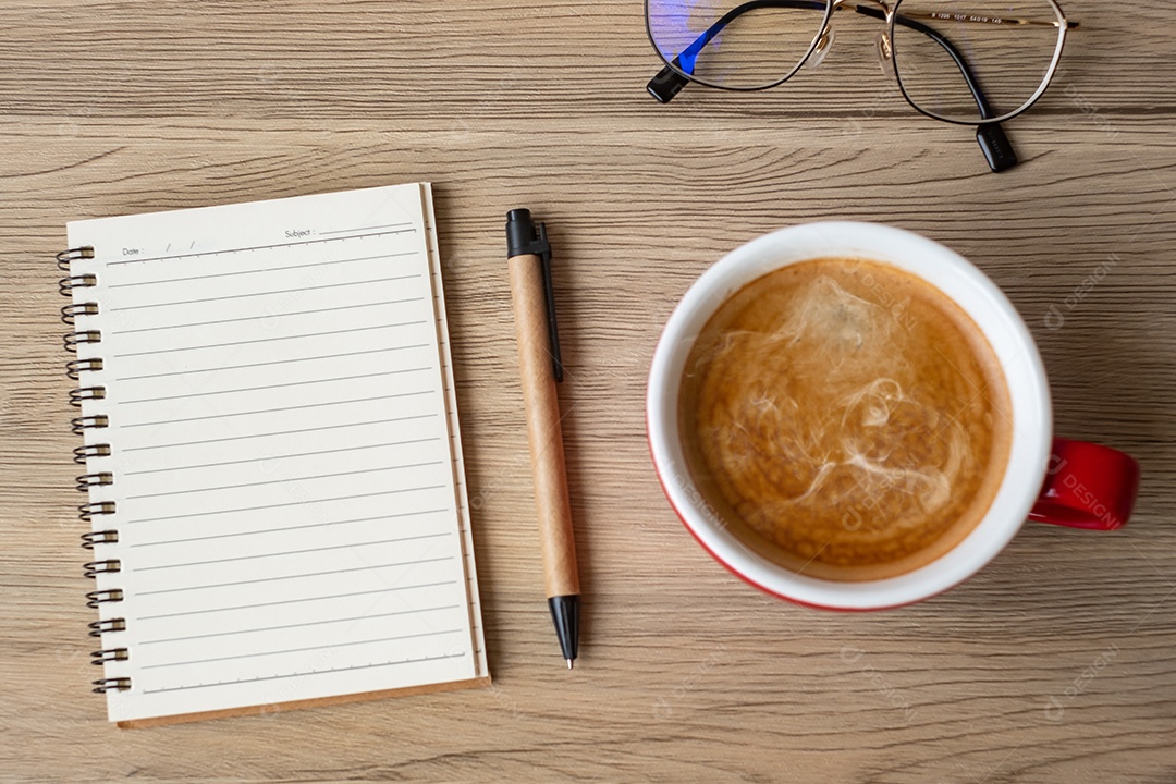 Caderno em branco e xícara de café na mesa de madeira. Motivação, determinação.