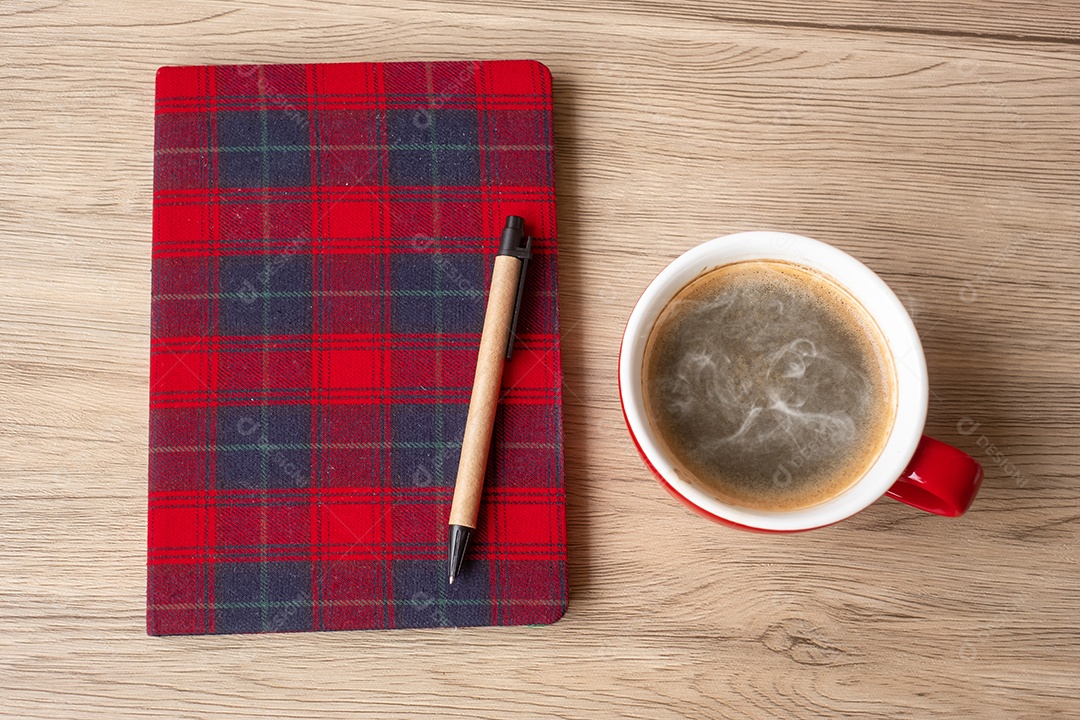 Caderno em branco, xícara de café e caneta na mesa de madeira. Feliz Ano Novo.