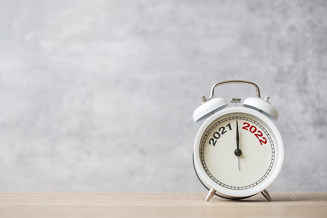 Despertador vintage no fundo da mesa de madeira.