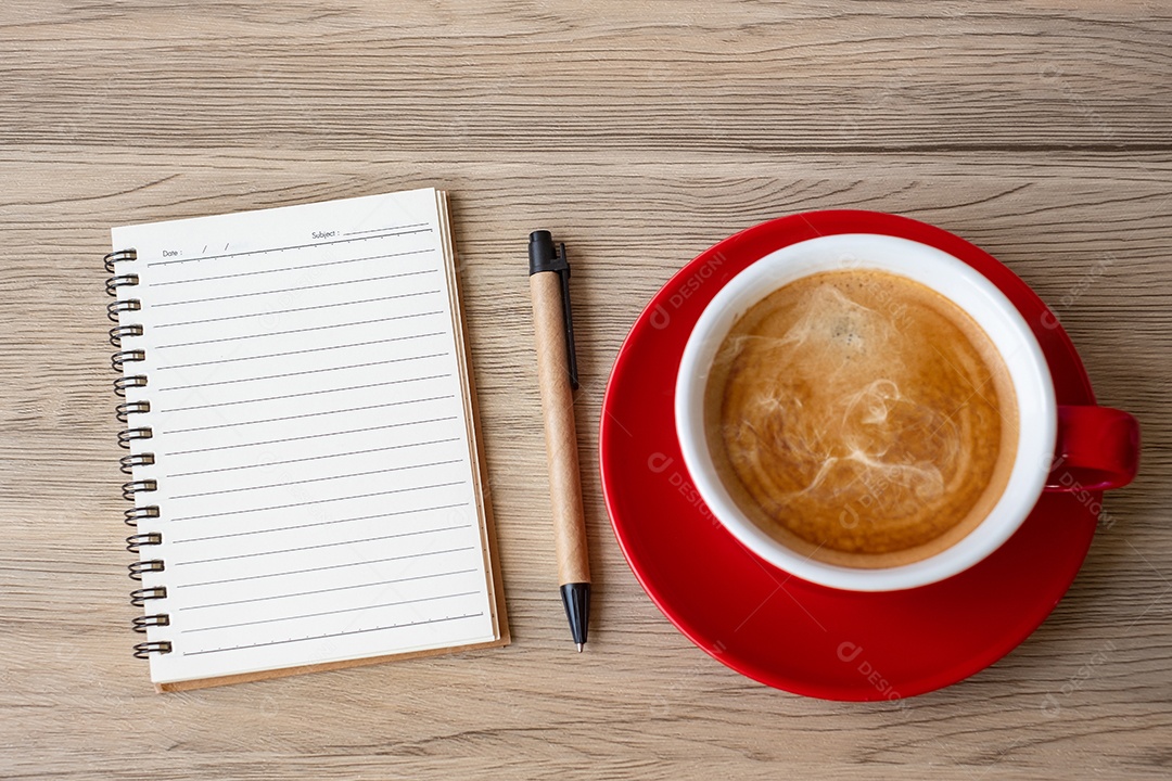 Caderno em branco e xícara de café na mesa de madeira. Motivação, determinação.