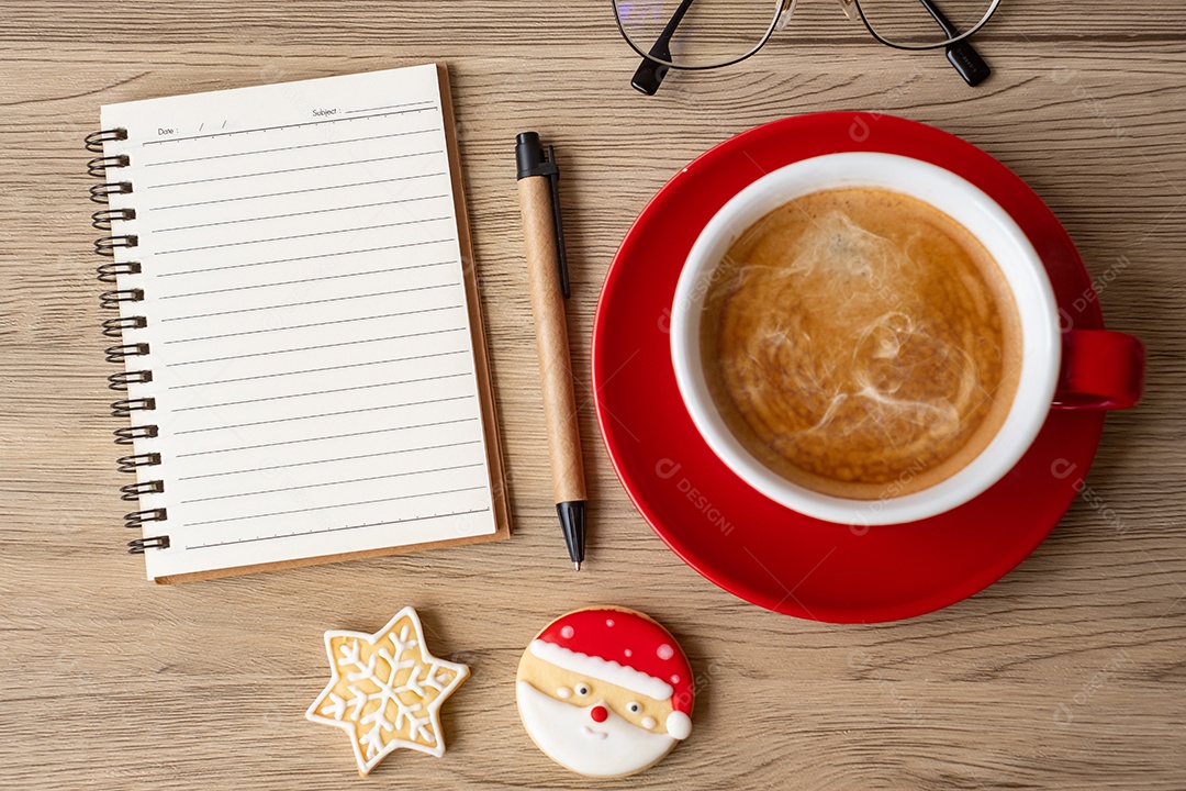 Caderno em branco, xícara de café preto, biscoitos de Natal e caneta.