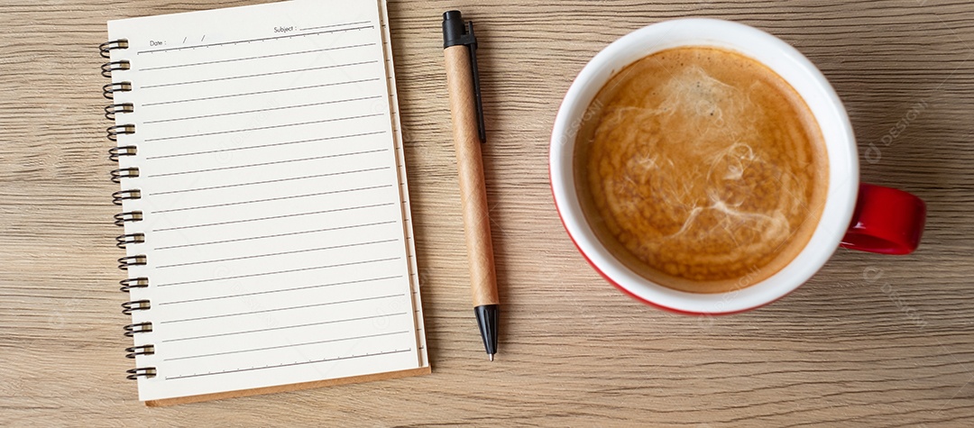 Caderno em branco e xícara de café na mesa de madeira. Motivação, determinação.