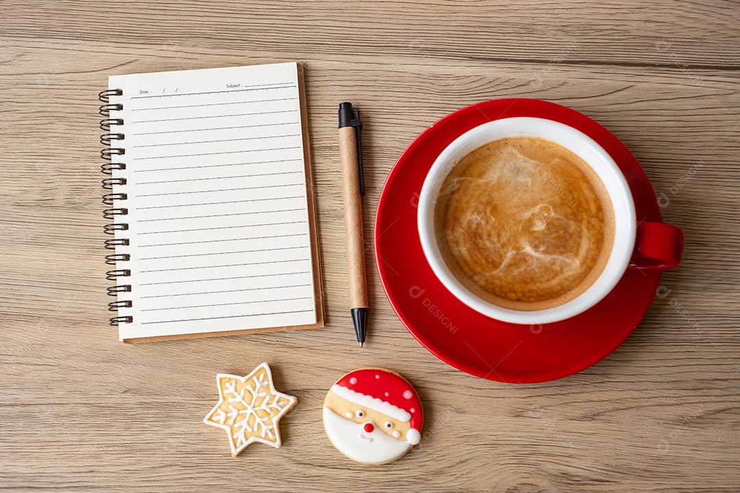 Caderno em branco, xícara de café preto, biscoitos de Natal e caneta.