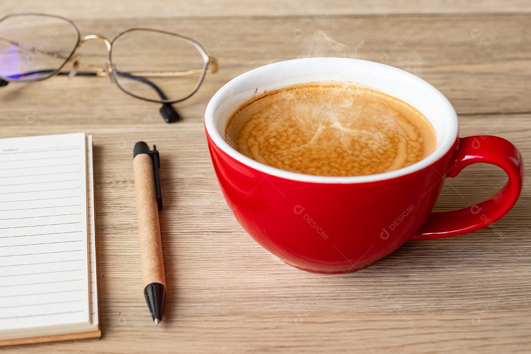 Caderno em branco e xícara de café na mesa de madeira. Motivação, determinação.