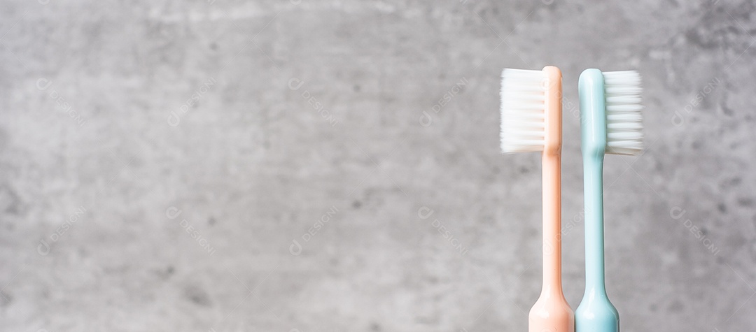 Conjunto de escovas de dentes no copo no fundo da parede no banheiro.