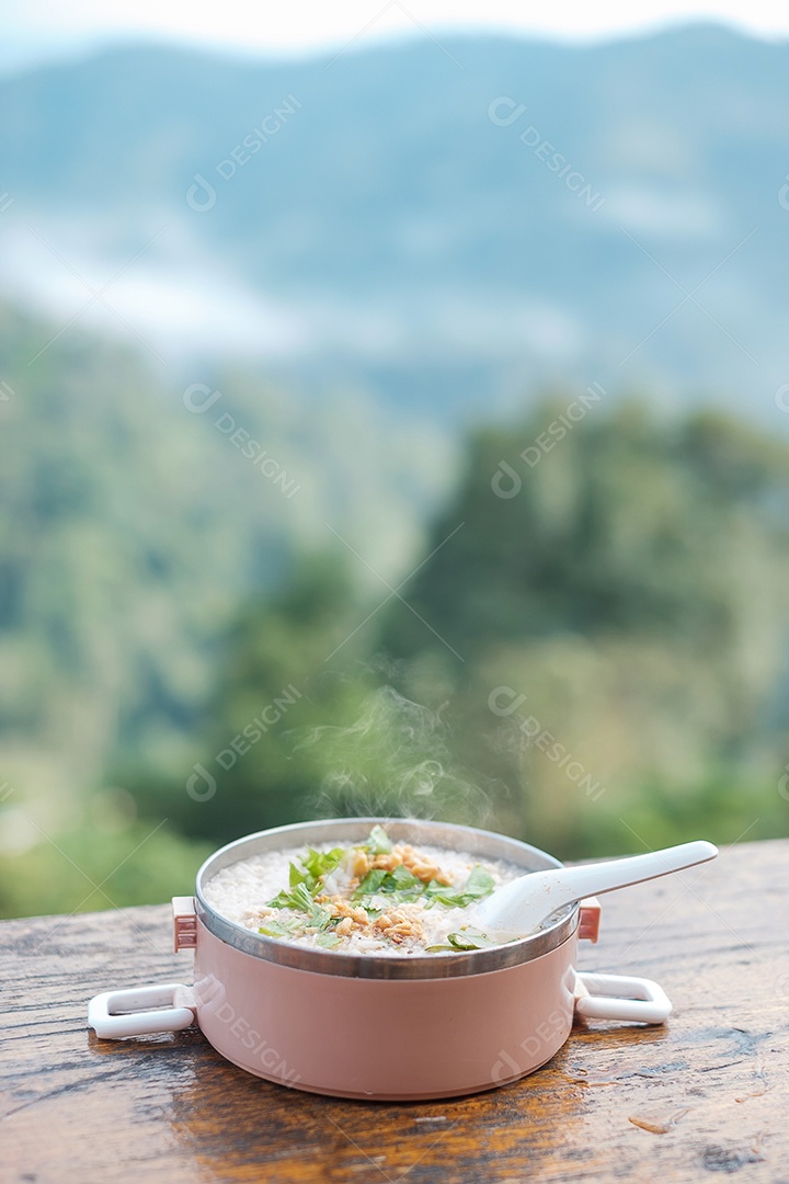 Mingau de porco ou sopa de arroz com carne de porco e legumes na mesa de madeira