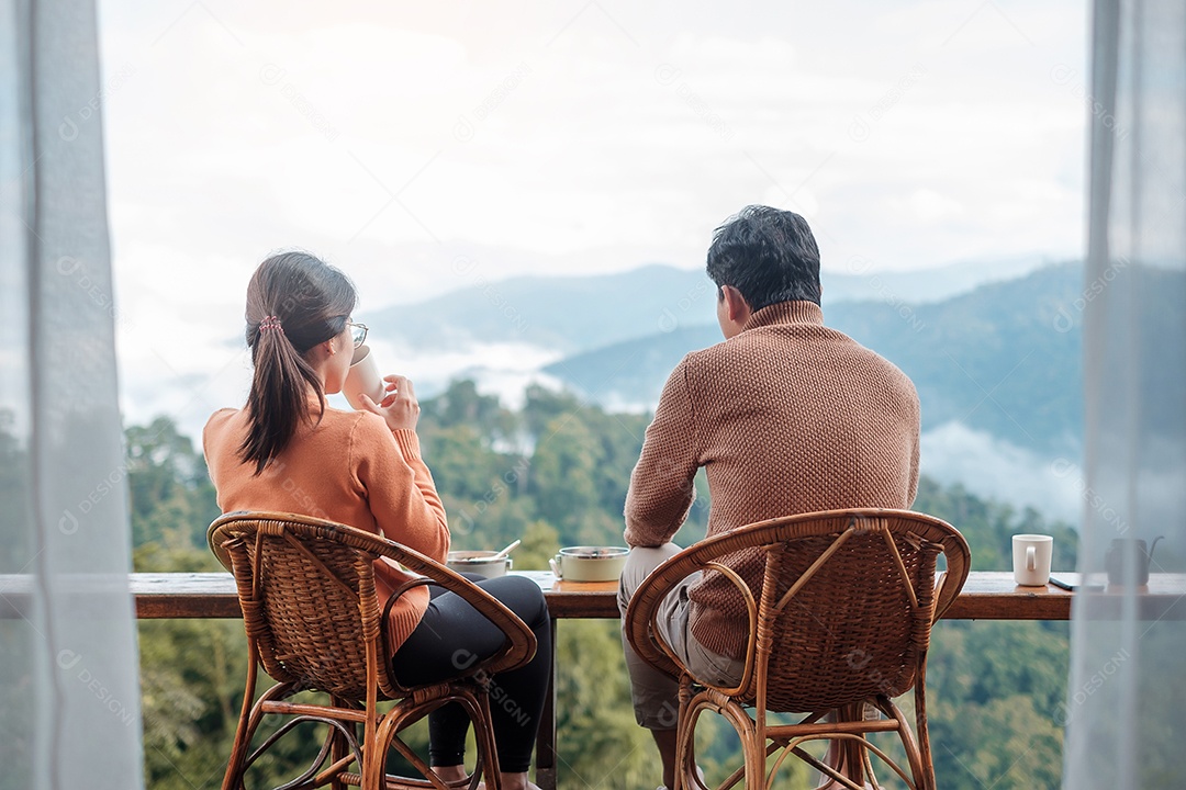 Casal turista tomando café e tomando café da manhã contra o monte
