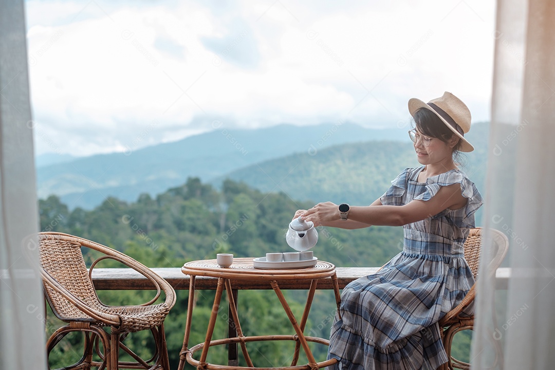 Mulher bebendo chá e olhando para a montanha.