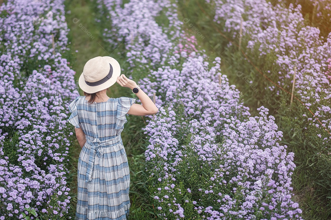 Feliz turista de vestido azul desfruta de Margaret roxa.