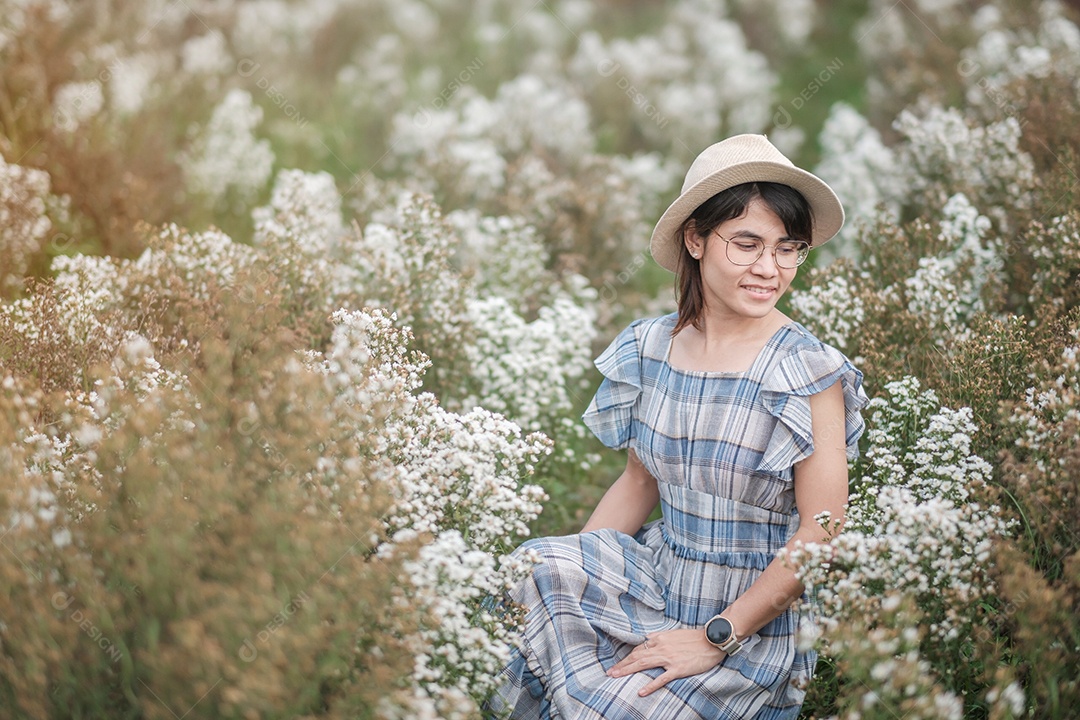 Feliz turista de vestido azul gosta de flor branca de Margaret.