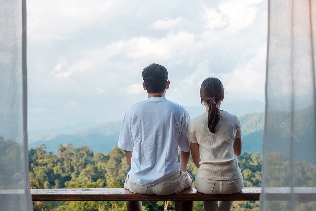 Turista de casal relaxando e olhando a vista para a montanha na zona rural.