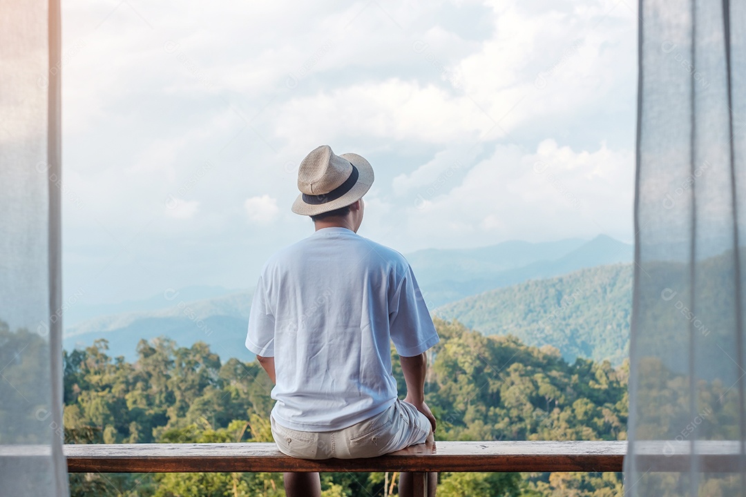 Homem de turista feliz relaxando e olhando a vista da montanha no país.