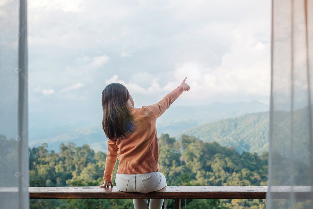 Happy woman relaxing and looking at mountain view in countryside.