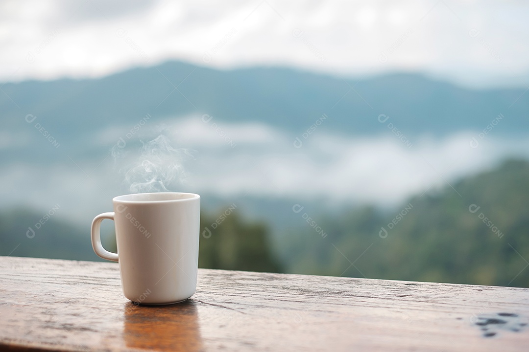 Caneca branca de café quente ou chá na mesa de madeira pela manhã.