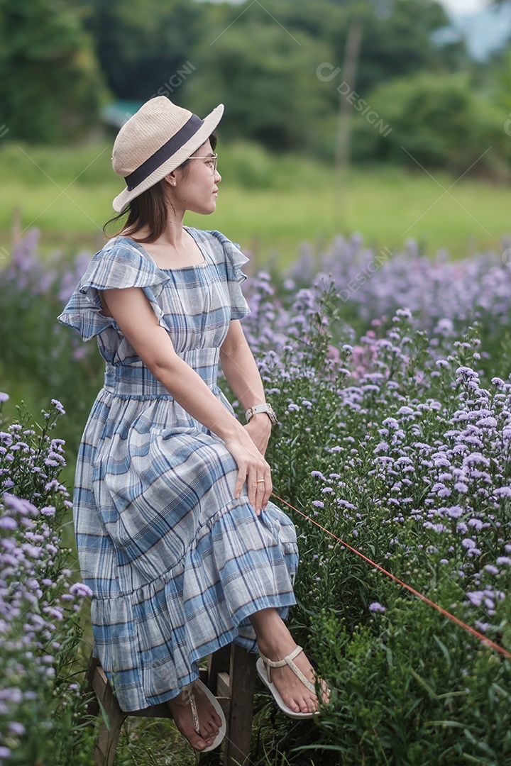 Feliz turista de vestido azul desfruta de Margaret roxa.