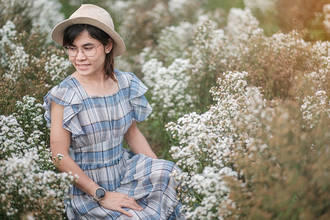 Feliz turista de vestido azul gosta de flor branca de Margaret.